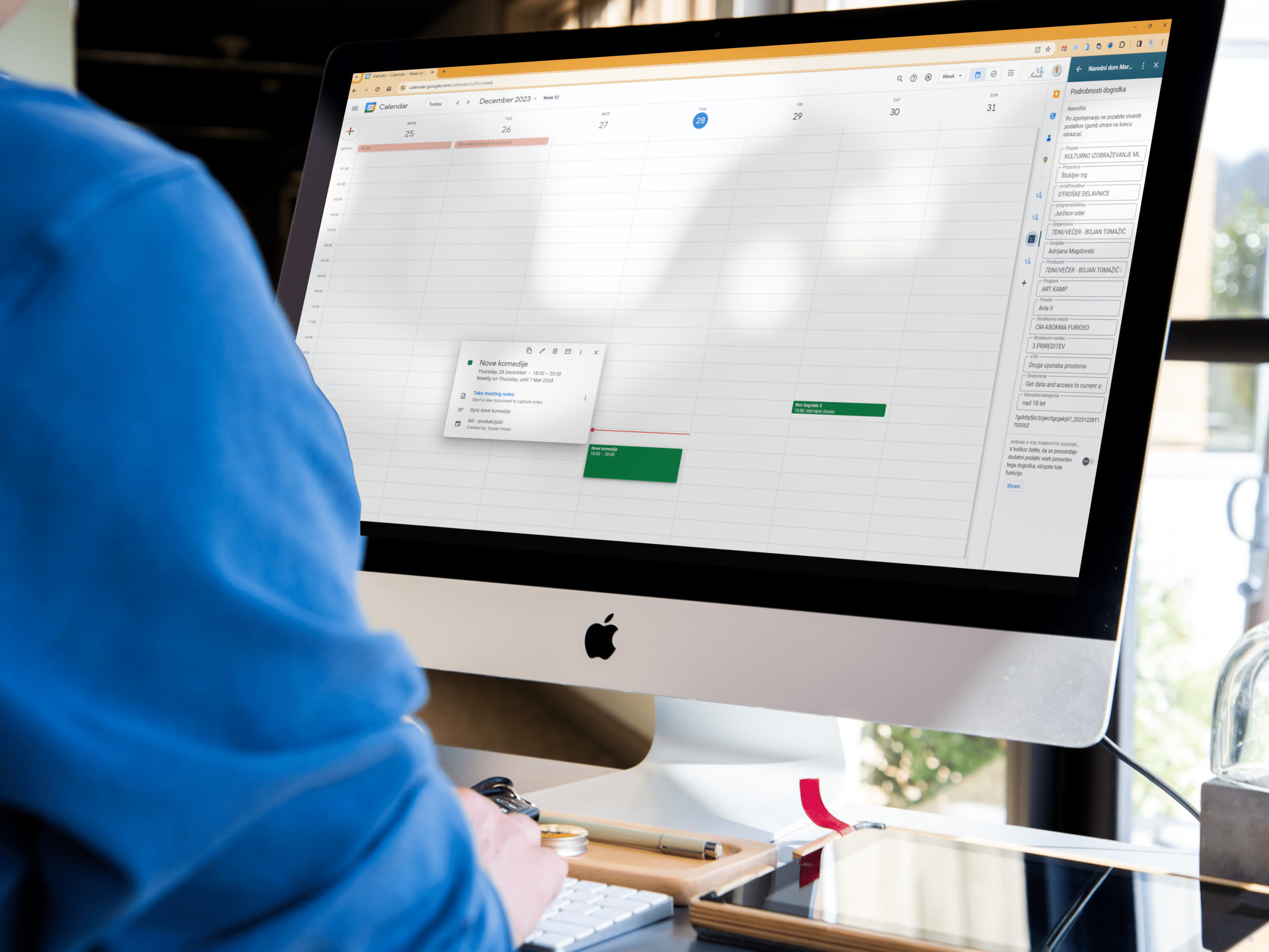 Oseba uporablja Google Koledar na zaslonu računalnika iMac za načrtovanje in upravljanje dogodkov.