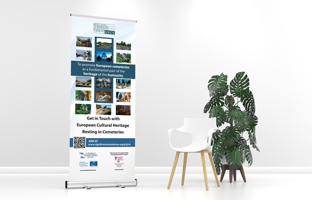 Roll-up stojalo za ASCE o evropskih pokopališčih, postavljeno ob belem stolu in sobni rastlini monstera.