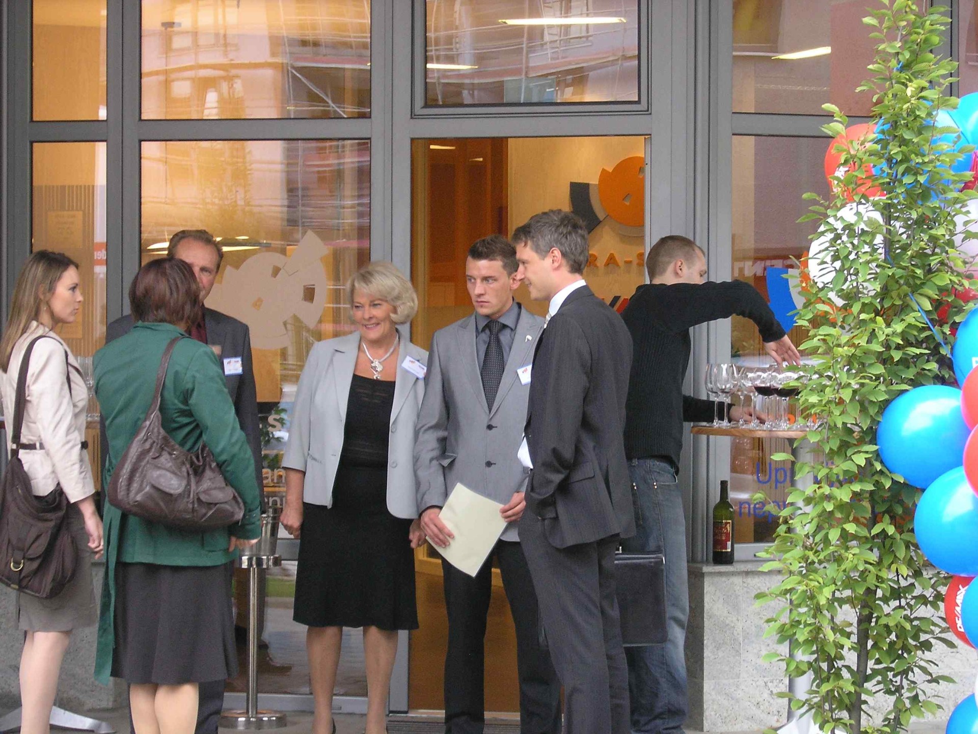 Poslovni partnerji se družijo pred vhodom v poslovne prostore med organiziranim dogodkom.
